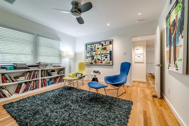 living area featuring hardwood / wood-style flooring and ceiling fan