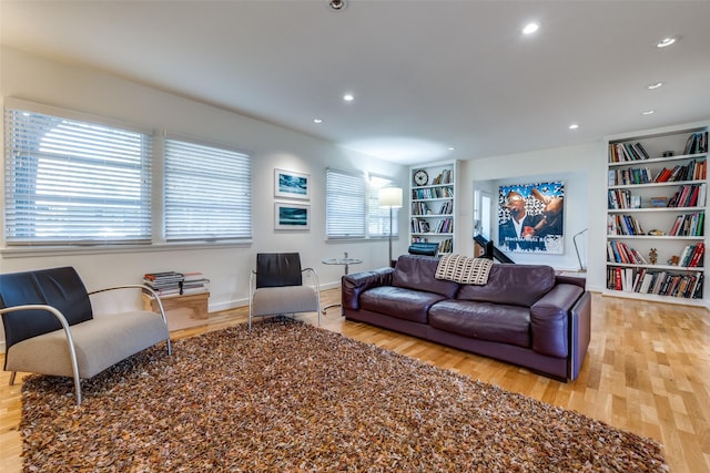 living room with built in shelves and light wood-type flooring