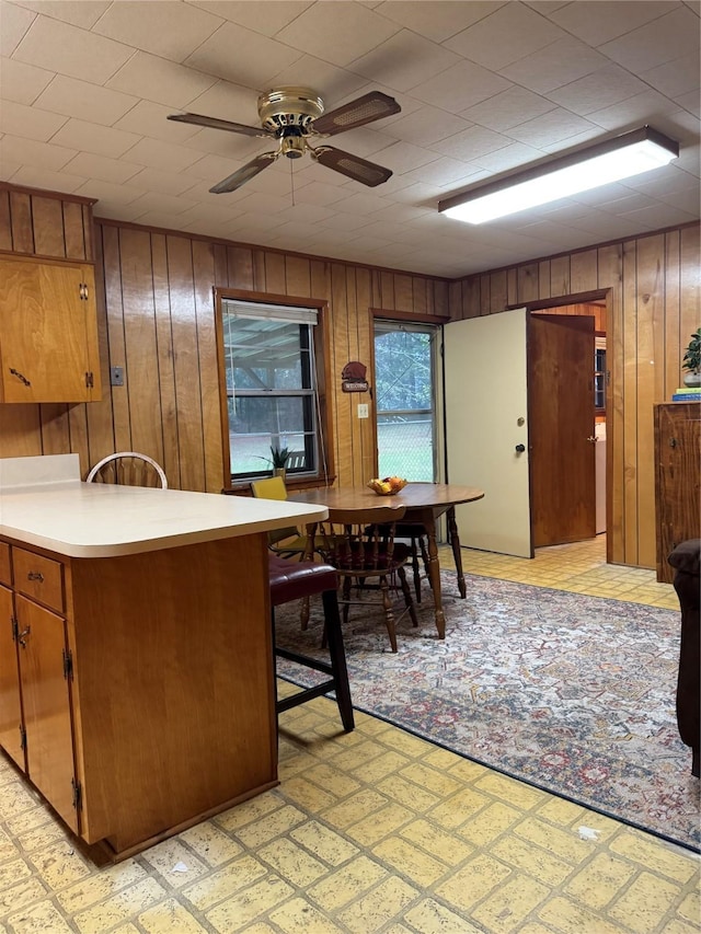 904 Uncas St, Logansport, LA 71049 - kitchen with kitchen peninsula, ceiling fan, and wood walls