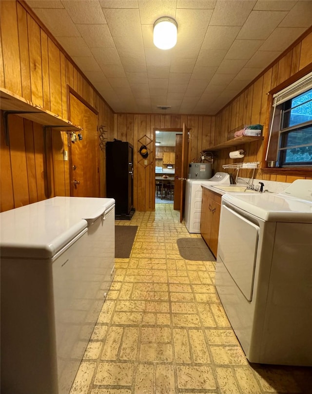 904 Uncas St, Logansport, LA 71049 - laundry room with cabinets, washing machine and clothes dryer, and wood walls
