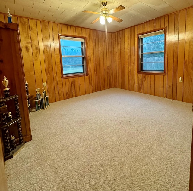 904 Uncas St, Logansport, LA 71049 - spare room with wooden walls, ceiling fan, and carpet flooring