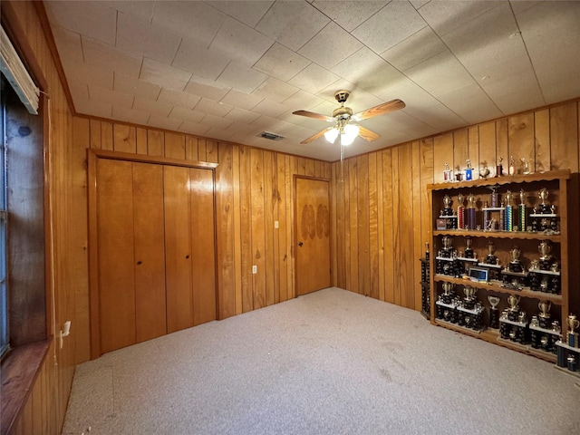 904 Uncas St, Logansport, LA 71049 - carpeted empty room featuring ceiling fan and wood walls