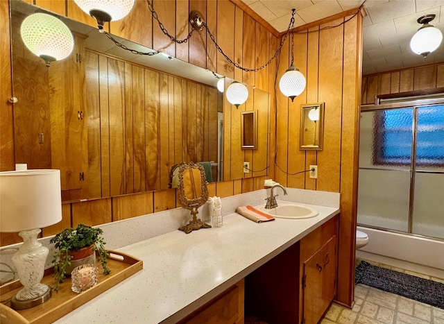 904 Uncas St, Logansport, LA 71049 - full bathroom with vanity, wooden walls, shower / bath combination with glass door, and toilet