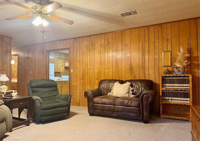904 Uncas St, Logansport, LA 71049 - carpeted living room featuring ceiling fan and wood walls