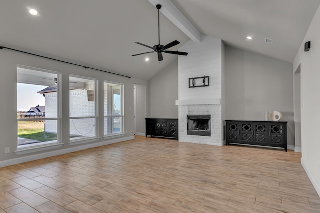 unfurnished living room featuring ceiling fan, beamed ceiling, high vaulted ceiling, light hardwood / wood-style floors, and a fireplace