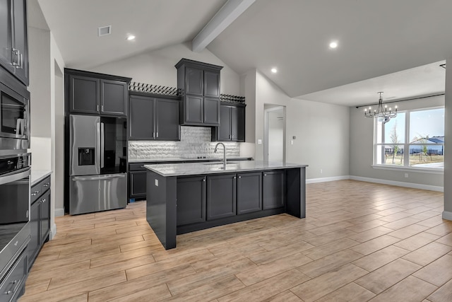 kitchen featuring beam ceiling, light hardwood / wood-style floors, stainless steel appliances, and a chandelier