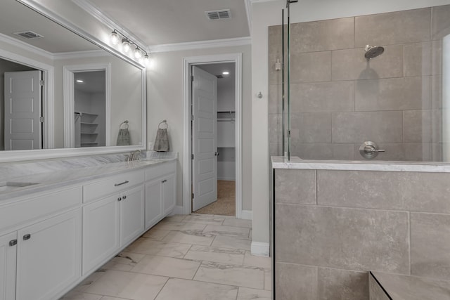 bathroom featuring a tile shower, vanity, and ornamental molding