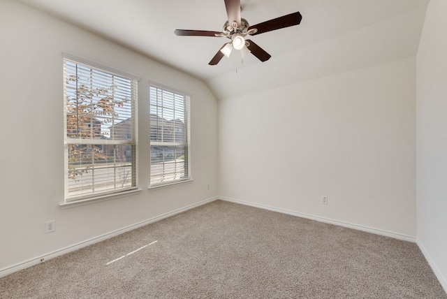 carpeted empty room with vaulted ceiling and ceiling fan