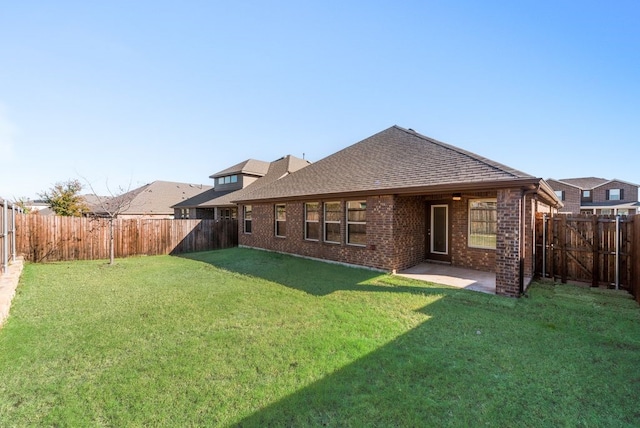 rear view of property with a yard and a patio