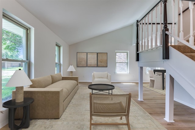 living room featuring light wood-type flooring and high vaulted ceiling