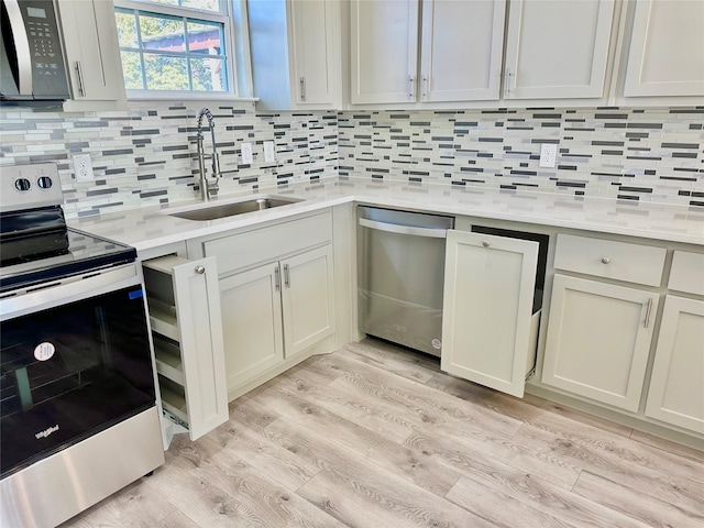 kitchen with decorative backsplash, sink, stainless steel appliances, and light hardwood / wood-style flooring