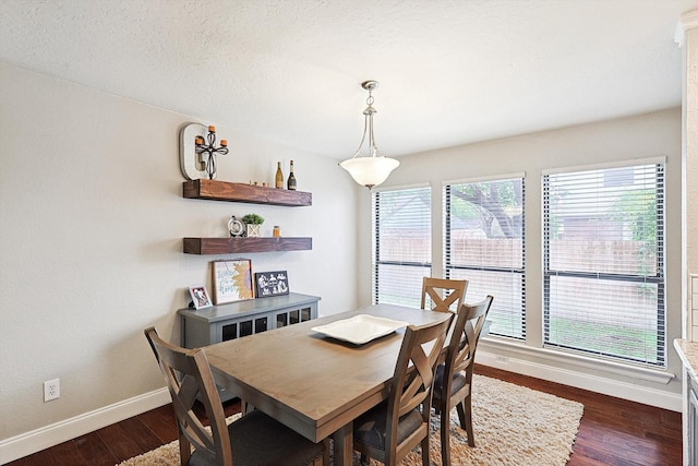 dining space with dark hardwood / wood-style floors and a textured ceiling