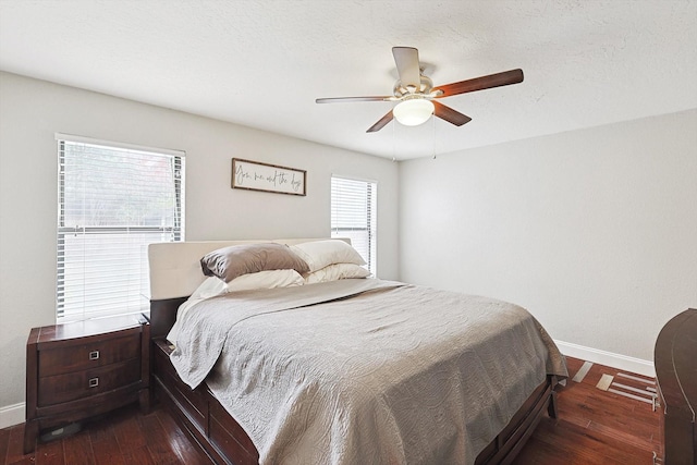 bedroom with ceiling fan, dark hardwood / wood-style floors, and a textured ceiling