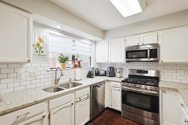 kitchen featuring appliances with stainless steel finishes, sink, decorative backsplash, and white cabinets