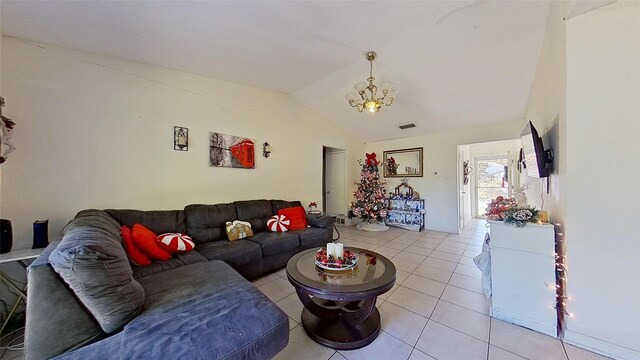 living room featuring light tile patterned flooring, an inviting chandelier, and vaulted ceiling