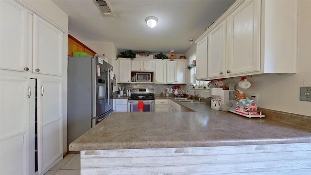 kitchen with white cabinetry, stainless steel appliances, kitchen peninsula, and sink