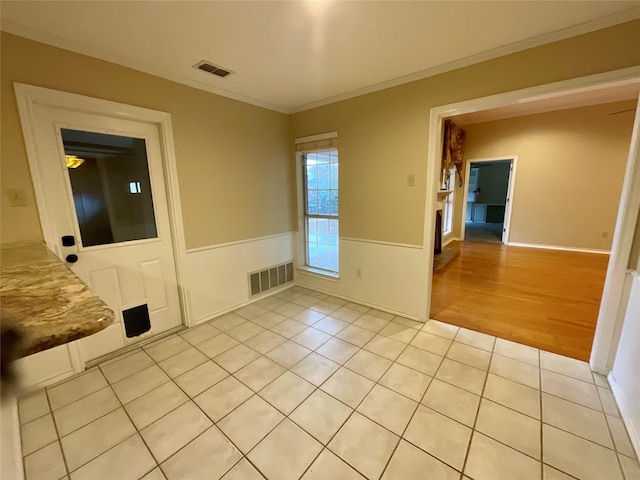 tiled spare room with ornamental molding