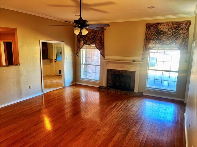 unfurnished living room featuring hardwood / wood-style floors, ornamental molding, a brick fireplace, and ceiling fan