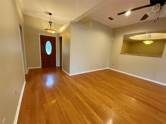 entryway with crown molding, ceiling fan, and wood-type flooring