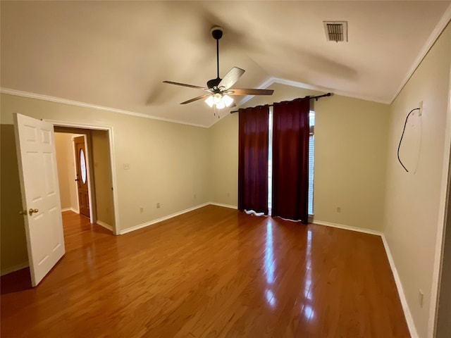 empty room with hardwood / wood-style flooring, ceiling fan, lofted ceiling, and crown molding