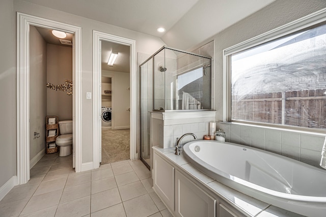 bathroom with toilet, washer / dryer, tile patterned floors, and independent shower and bath