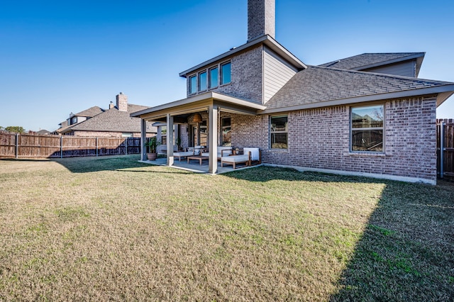 rear view of house featuring an outdoor living space, a patio, and a lawn