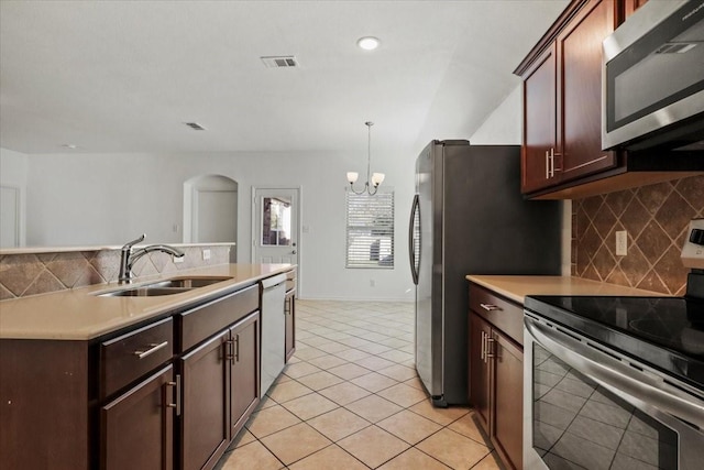 kitchen with sink, stainless steel appliances, backsplash, pendant lighting, and a chandelier