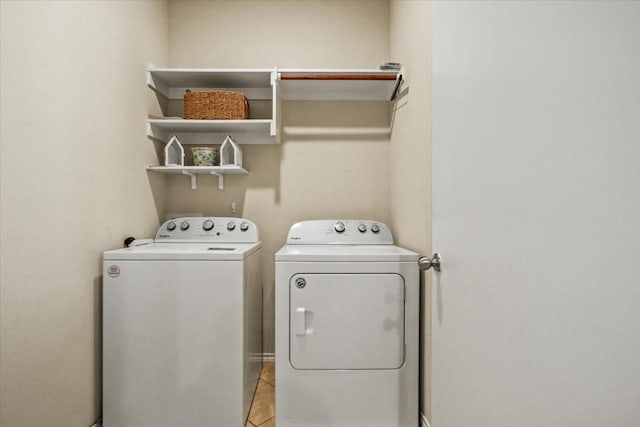 clothes washing area featuring light tile patterned flooring and independent washer and dryer