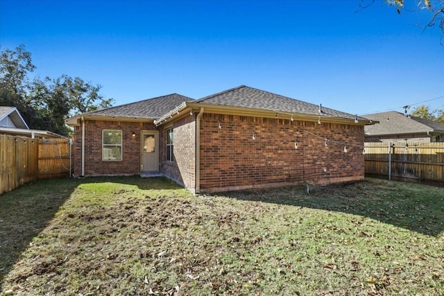 back of house with a lawn