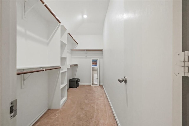 spacious closet with light carpet and vaulted ceiling