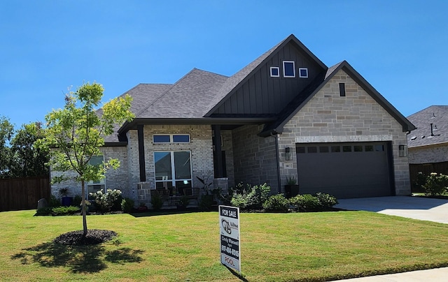 view of front of property featuring board and batten siding, a front yard, roof with shingles, driveway, and an attached garage