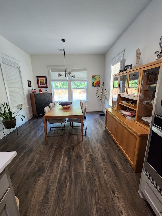 dining area with an inviting chandelier and dark hardwood / wood-style floors