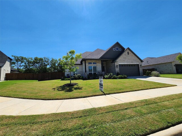 craftsman house featuring a garage and a front lawn