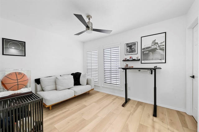 living area with ceiling fan and light hardwood / wood-style flooring