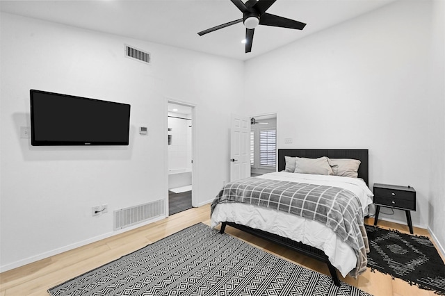 bedroom featuring hardwood / wood-style flooring, ceiling fan, and ensuite bath