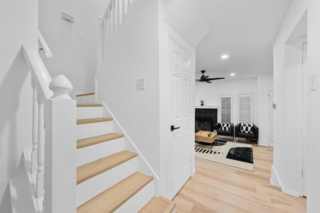 stairs featuring hardwood / wood-style flooring and ceiling fan