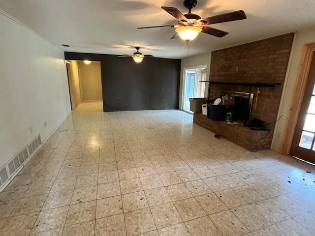 unfurnished living room featuring ceiling fan and a fireplace