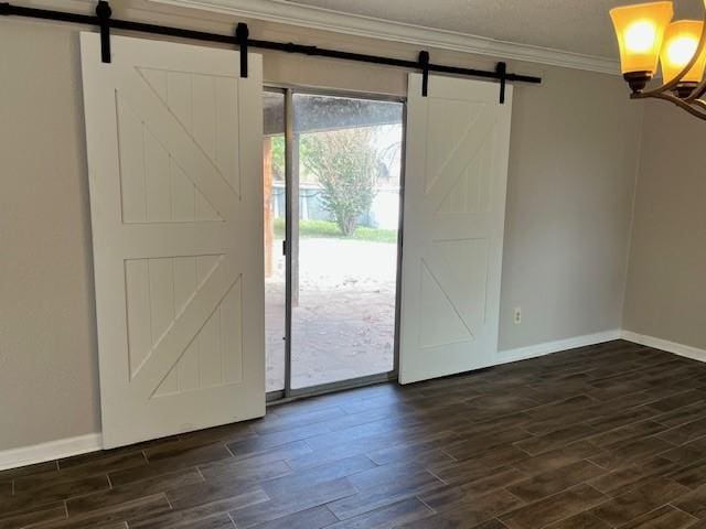 entrance foyer featuring dark wood-type flooring, ornamental molding, and a barn door