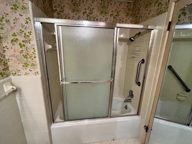 bathroom with tile patterned floors and shower / bath combination with glass door