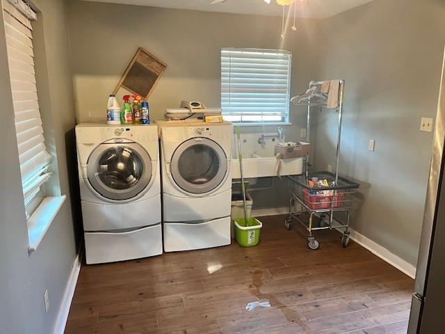 clothes washing area with washing machine and dryer, wood-type flooring, sink, and ceiling fan