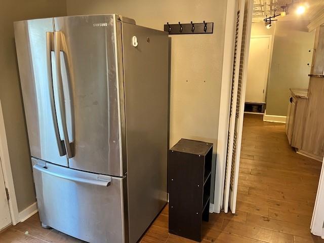 kitchen with hardwood / wood-style floors and stainless steel fridge