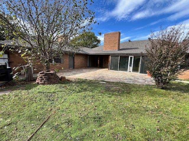 back of house featuring a yard and a patio area