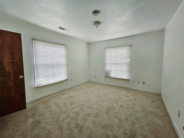 carpeted empty room featuring a textured ceiling