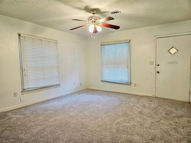 carpeted spare room featuring ceiling fan and a textured ceiling