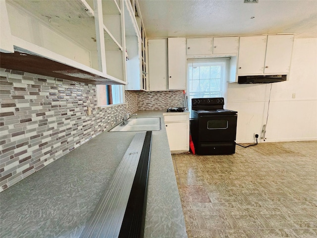 kitchen featuring tasteful backsplash, black electric range, white cabinets, and sink