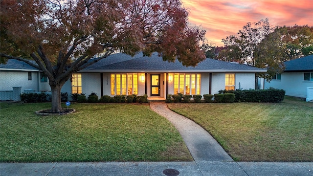 ranch-style home with a lawn