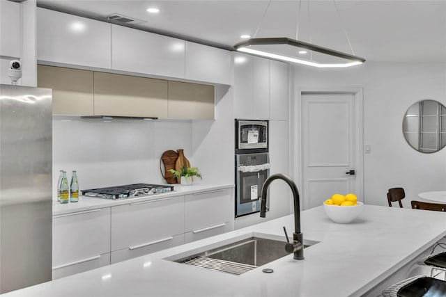 kitchen with white cabinets, a breakfast bar, stainless steel appliances, and sink