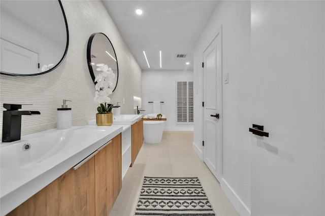 bathroom featuring tile patterned floors, vanity, and a tub to relax in