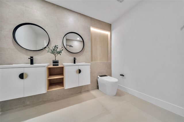 bathroom with tile patterned flooring, vanity, toilet, and tile walls