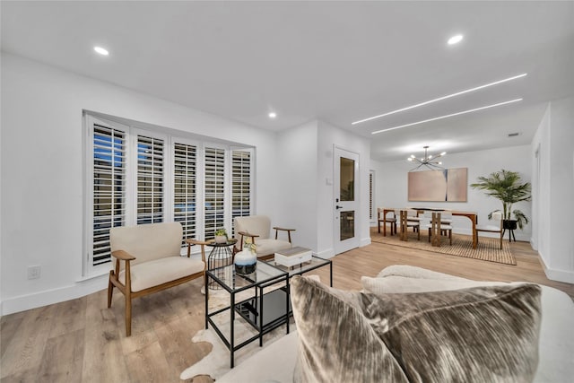 living room with a chandelier and light wood-type flooring